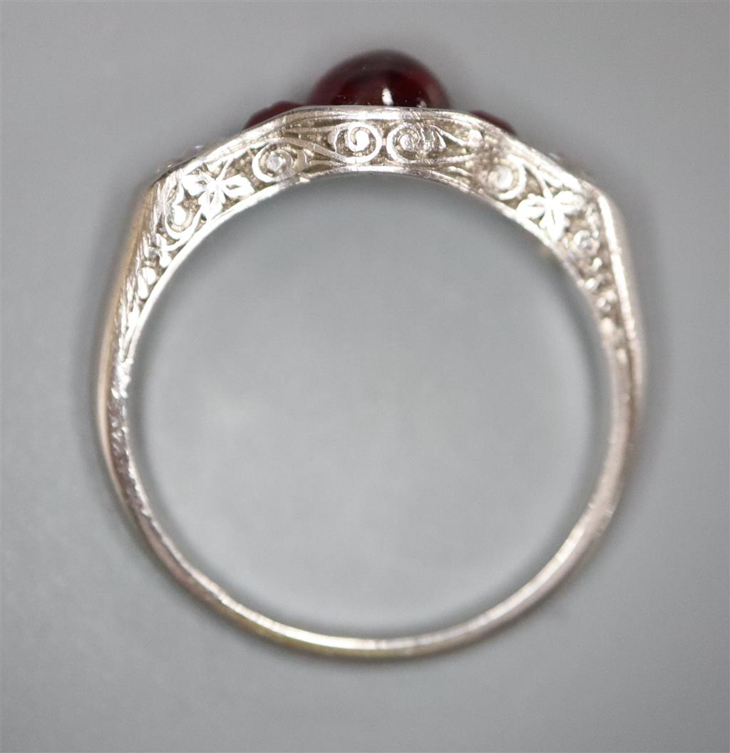 A modern white metal (possibly platinum?), ruby and diamond dress ring,
